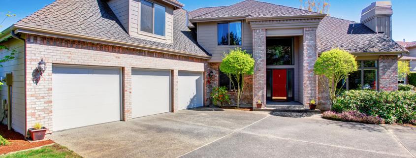 Large modern house with three garage spaces and concrete drivewa